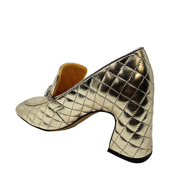 Gold quilted high-heeled shoe on a white background