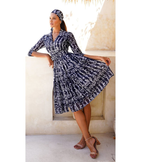 A knee-length dress with a collared neckline, three-quarter sleeves, and a flared skirt. Features a bold allover abstract pattern and fitted waist.