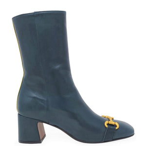 Blue ankle boot with gold buckle on a white background