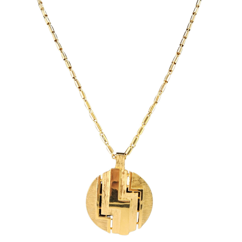Gold necklace with a geometric pendant on a white background