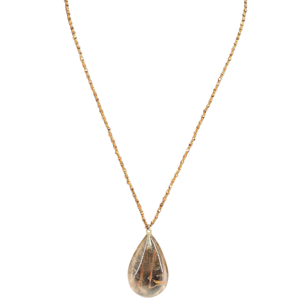 Teardrop-shaped pendant on a gold chain against a white background