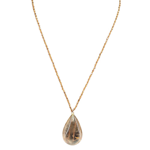 Teardrop-shaped pendant on a gold chain against a white background