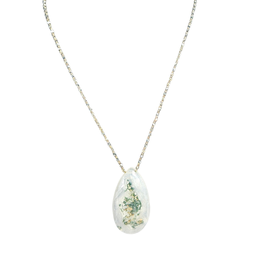 Teardrop-shaped pendant with floral design on a white background