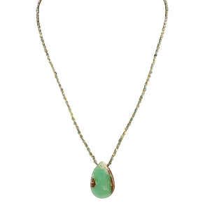Necklace with a green teardrop pendant on a white background