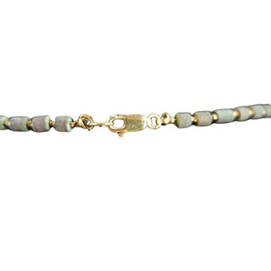 Bracelet with gray beads and gold clasp on a white background