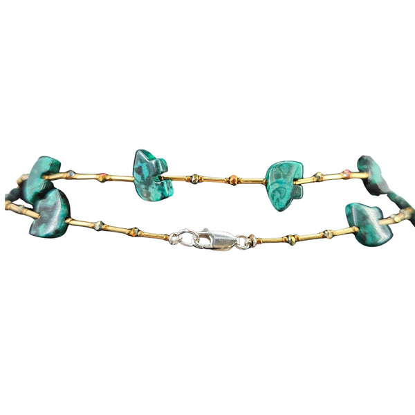 Gold bracelet with turquoise stones on a white background