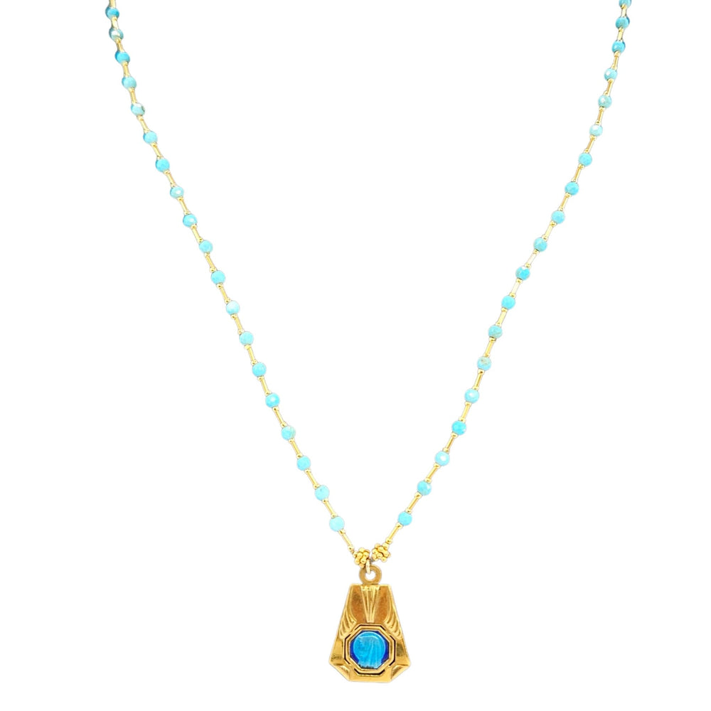Necklace with turquoise beads and a gold pendant on a white background