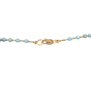 Gold bracelet with blue beads on a white background
