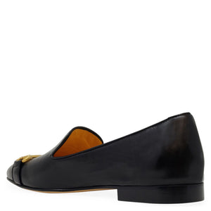 Black loafer shoe with gold accent on a white background