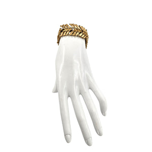 White mannequin hand wearing a gold bracelet on a white background