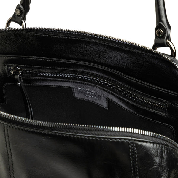 Close-up of a black leather bag with visible brand name, open to show interior.