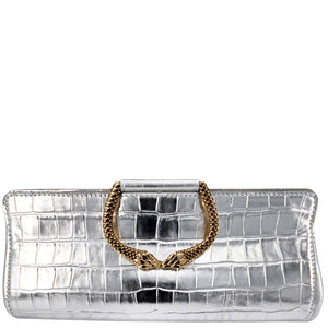 Silver clutch with gold chain handle on a white background