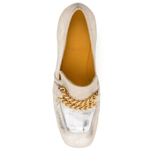 Silver slip-on shoe with gold chain detail on a white background