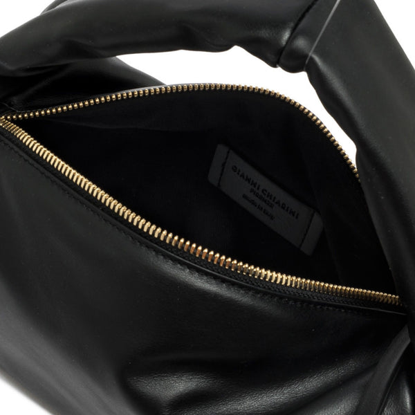 Close-up of a black leather bag with gold zipper, brand label visible.