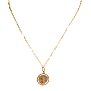Gold necklace with a round pendant on a white background