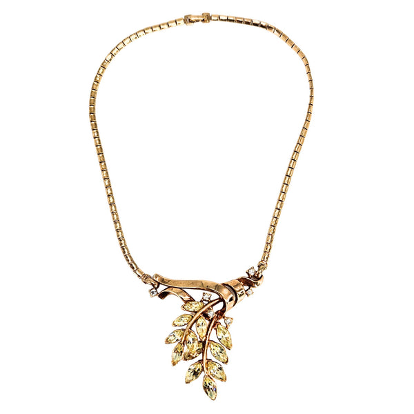 Gold necklace with leaf-shaped pendant on a white background