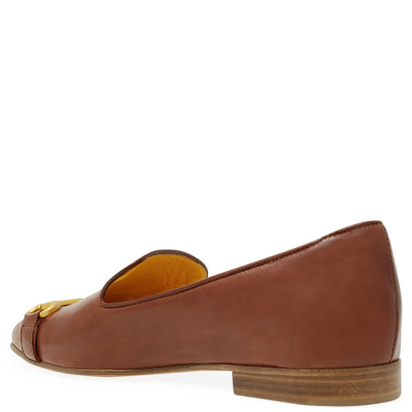 Brown loafer shoe with a gold buckle on a white background
