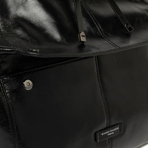Close-up of a black leather bag with a brand label.