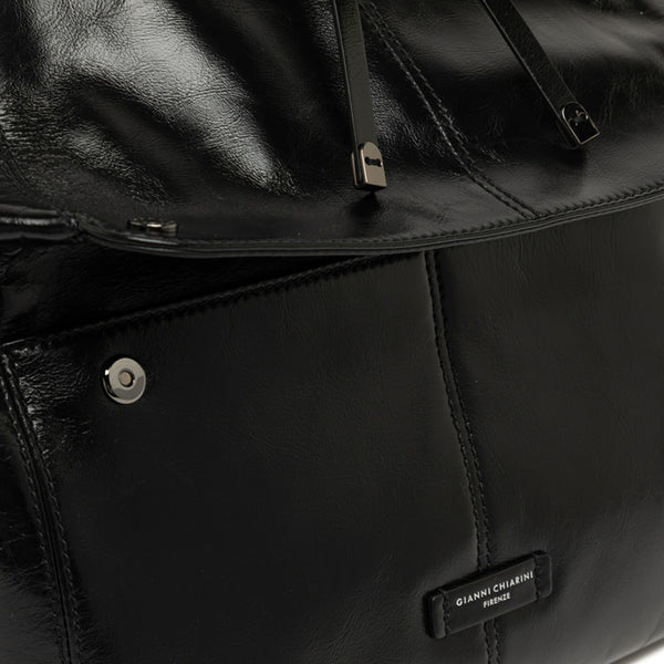 Close-up of a black leather bag with a brand label.