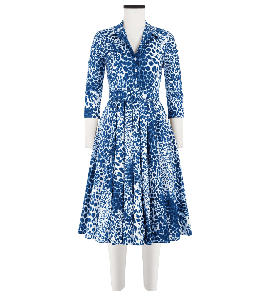A knee-length dress with a collared neckline, three-quarter sleeves, and a flared skirt. Features a bold allover abstract pattern and fitted waist.