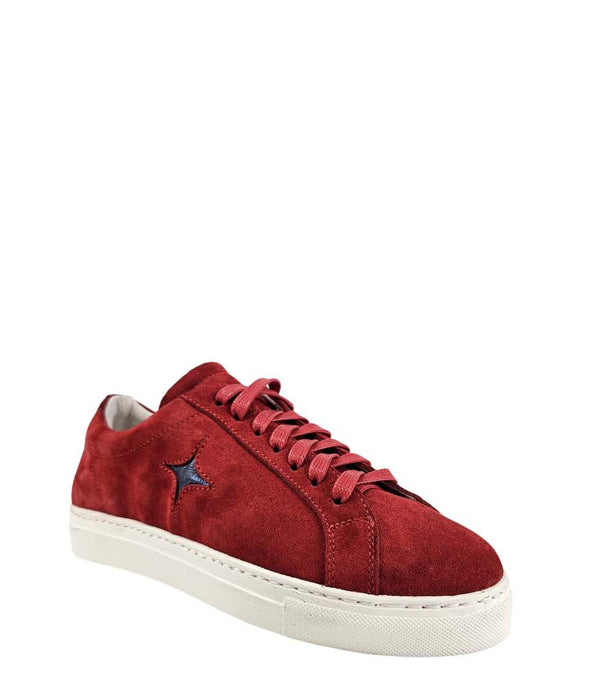  Side profile of a red suede sneaker with a dark blue star applique on the outer side. The sneaker features red laces, a white rubber sole, and a light-colored lining.