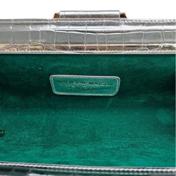 Green handbag with a visible brand label on a clear background