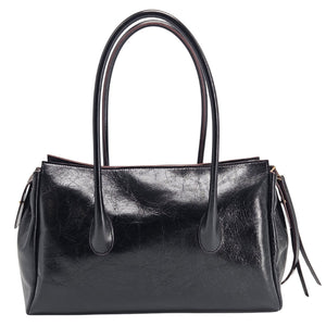 A sleek, black leather handbag with two slender top handles and a horizontal gold bar accent on the front.