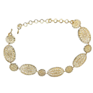 Gold bracelet with intricate designs on a white background