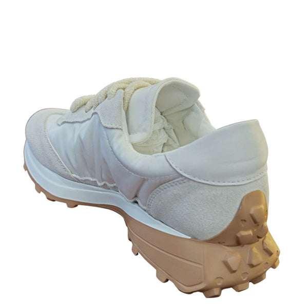 White sneaker with beige sole on a white background