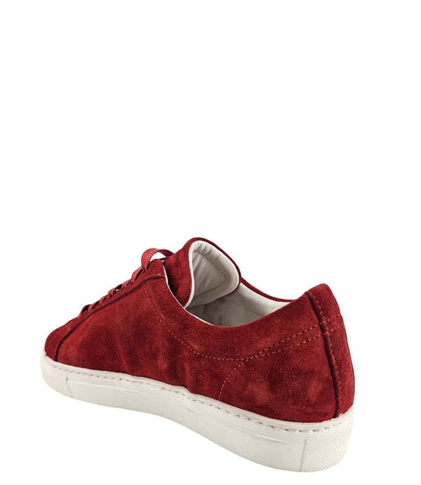  Side profile of a red suede sneaker with a dark blue star applique on the outer side. The sneaker features red laces, a white rubber sole, and a light-colored lining.