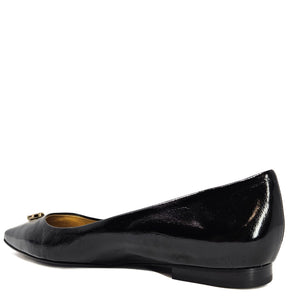 Black patent leather flat shoe on a white background