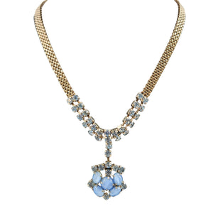 Necklace with blue floral pendant and gold chain on a white background