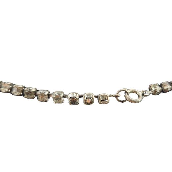 Silver bracelet with clear gemstones on a white background