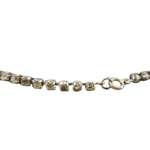 Silver bracelet with clear gemstones on a white background