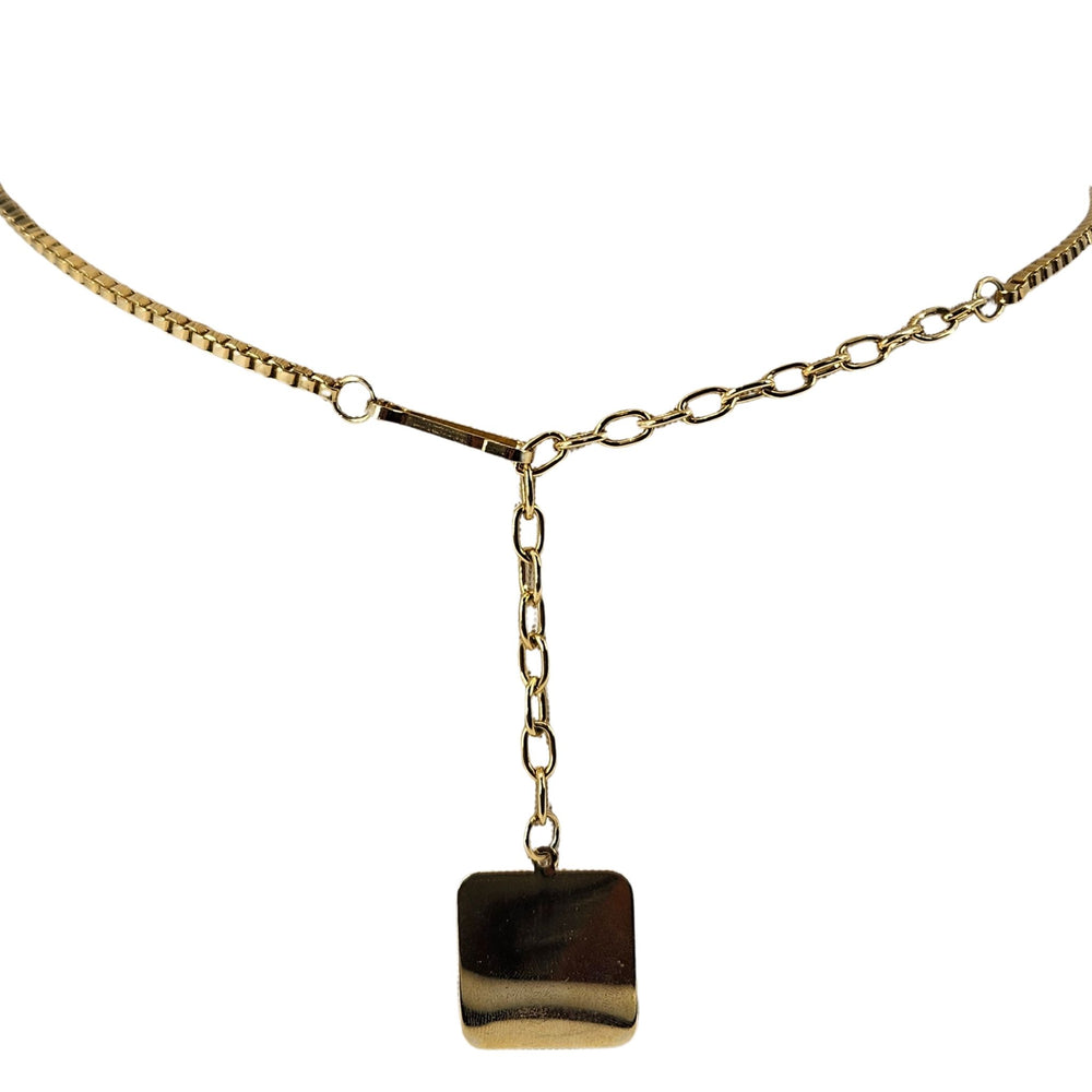Gold necklace with a square pendant on a white background