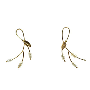 Gold leaf-shaped earrings with beads on a white background