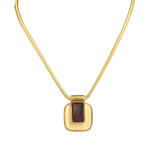 Gold necklace with a square pendant on a white background