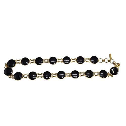 Gold bracelet with black beads on a white background