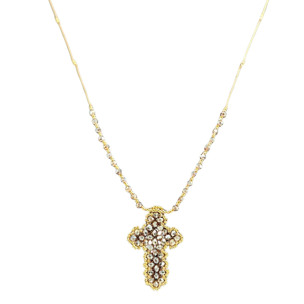 Gold cross necklace with pearl-like stones on a white background