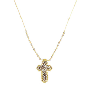 Gold cross necklace with pearl-like stones on a white background