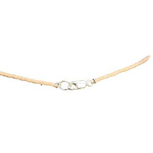 Necklace with a beige cord and silver clasp on a white background