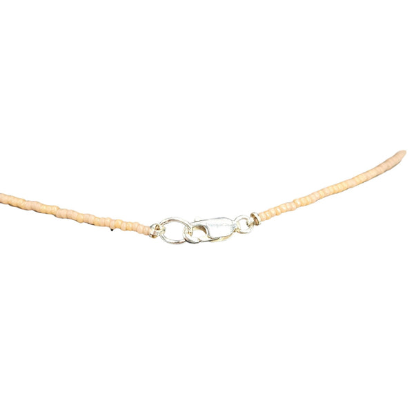 Necklace with a beige cord and silver clasp on a white background
