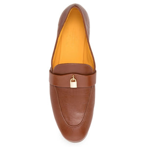 Brown leather loafer with gold buckle on a white background