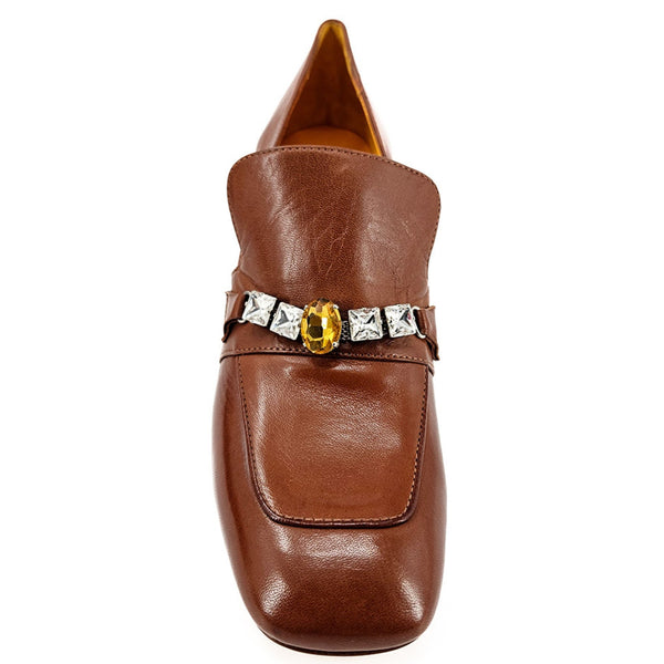 Brown leather shoe with decorative buckle on a white background