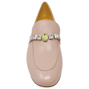 Pink loafer with a decorative brooch on a white background