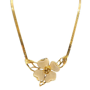 Gold necklace with a floral pendant on a white background