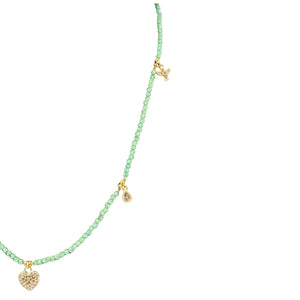 Green beaded necklace with gold heart pendants on a white background