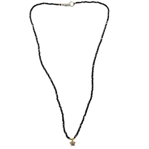 Black beaded necklace with a star pendant on a white background