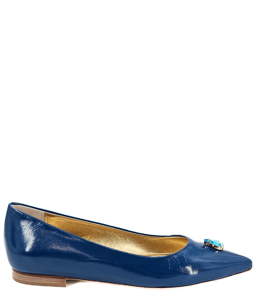 Pointed-toe slingback flat featuring a low block heel, textured fabric upper, slim ankle strap with side buckle, and a large jeweled buckle embellishment on the toe