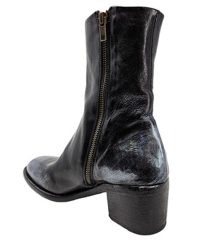 Mid-heel ankle boot crafted from premium leather with a softly rounded toe, artisanal distressed detailing at the toe and heel, and a stacked block heel. Features a full side zipper for easy entry, a leather-lined interior for comfort, and a durable leath